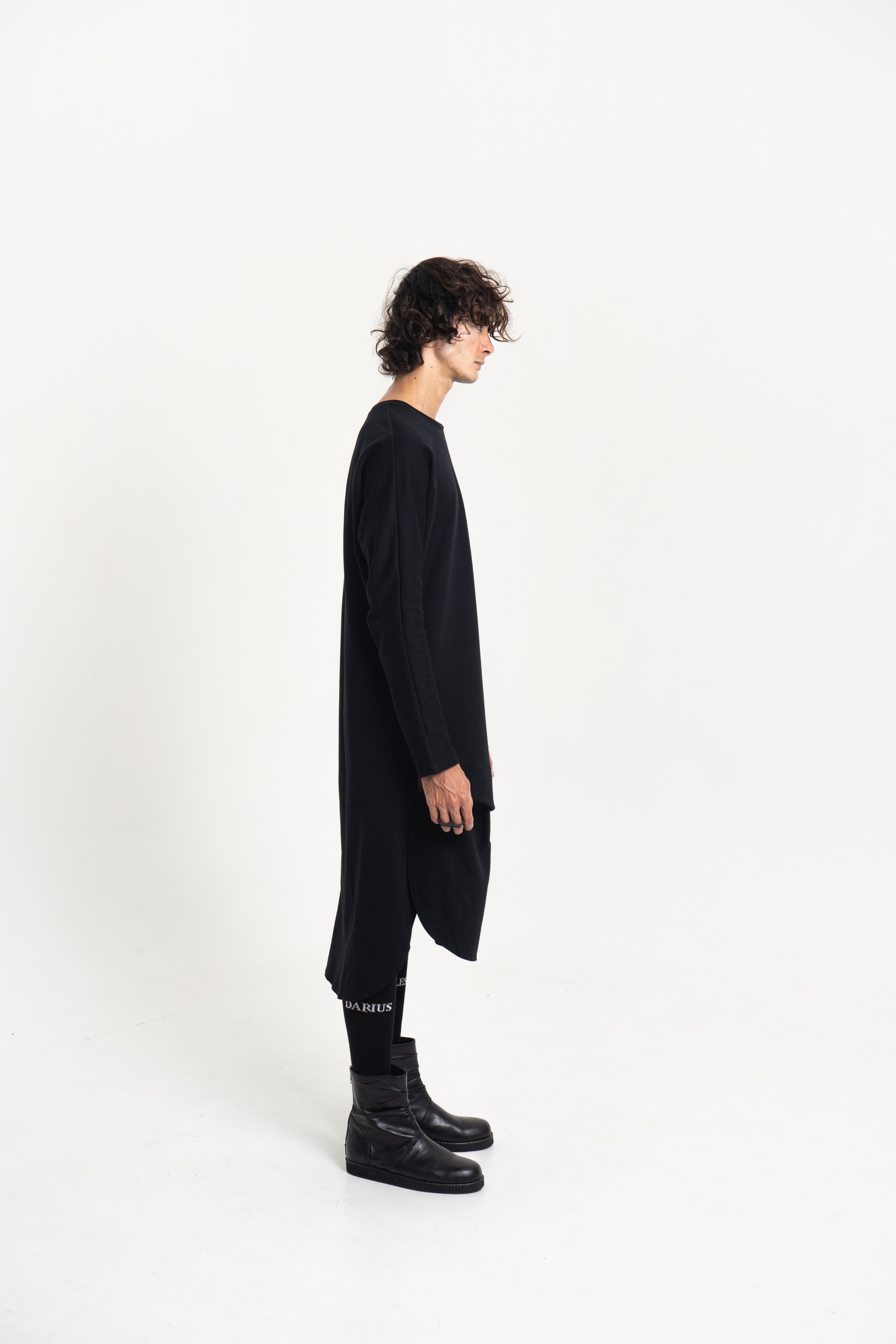 Side profile of the Origami Tunic Shirt showing drape and length, in black, studio shot