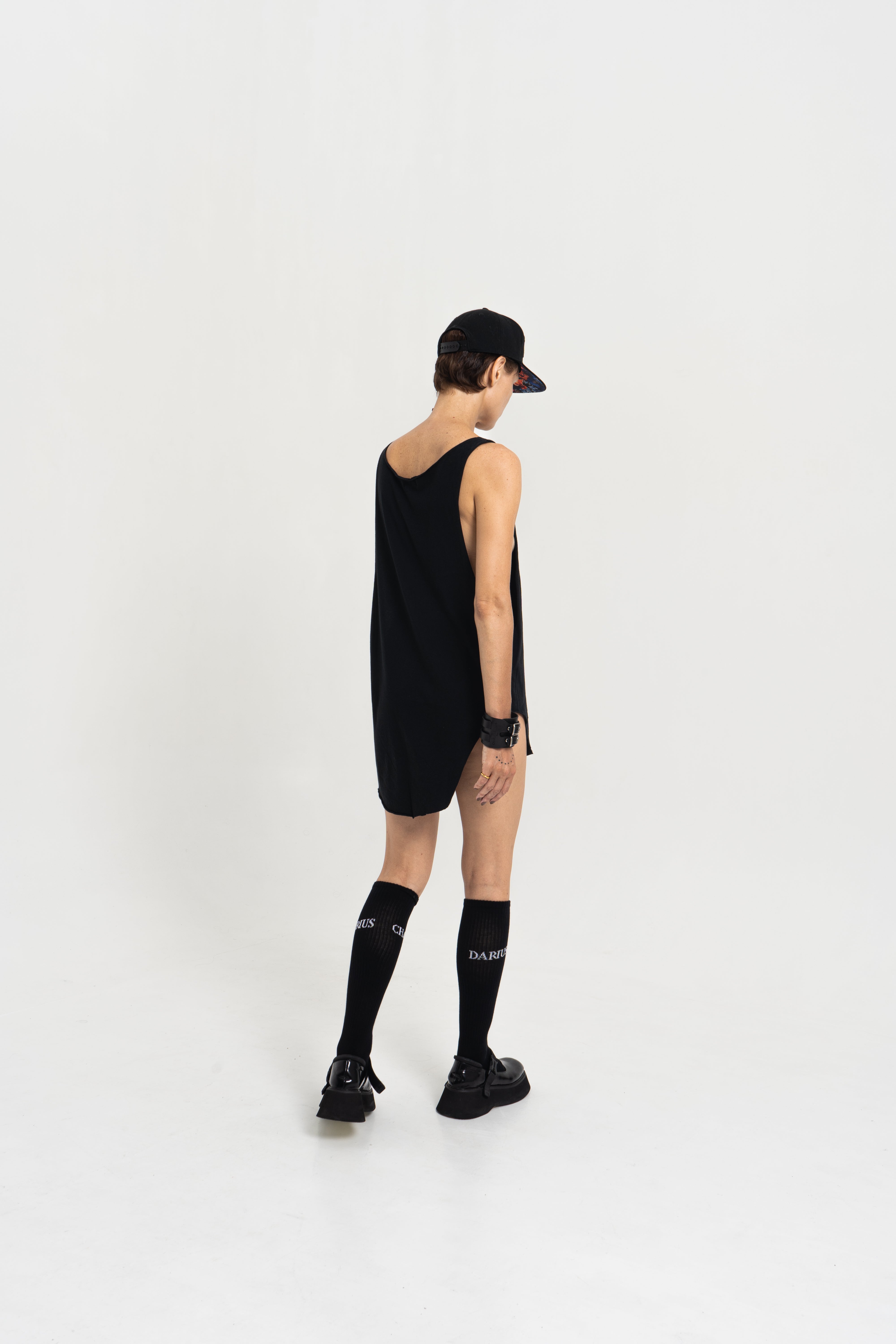 Model wearing the Charles Darius Deep Crew-Neck Tank Top in black, photographed from the back against a white studio background.