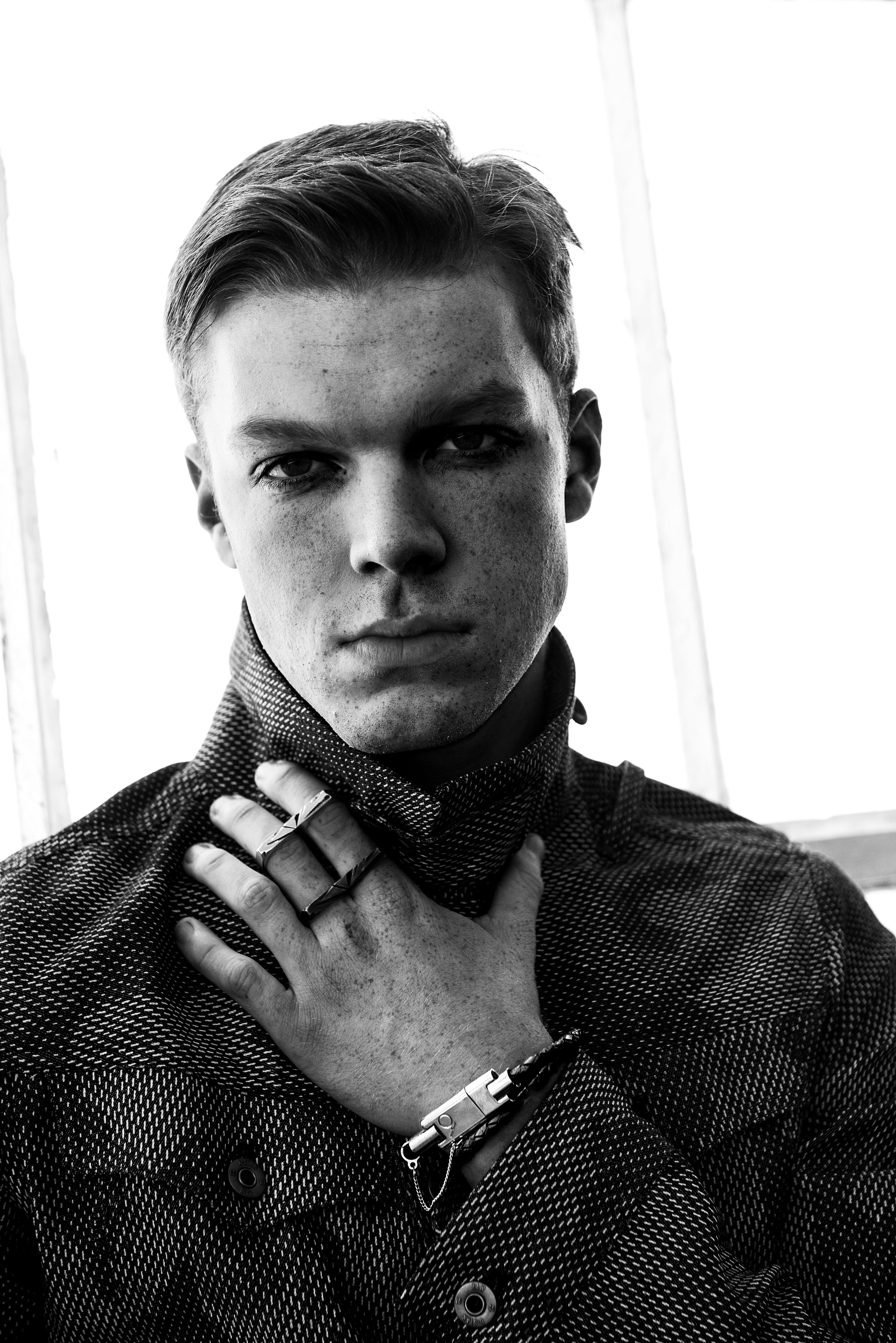 Black and white editorial portrait of a man wearing the Bolt leather Apple Lightning charging bracelet, shown as a luxury wearable tech accessory