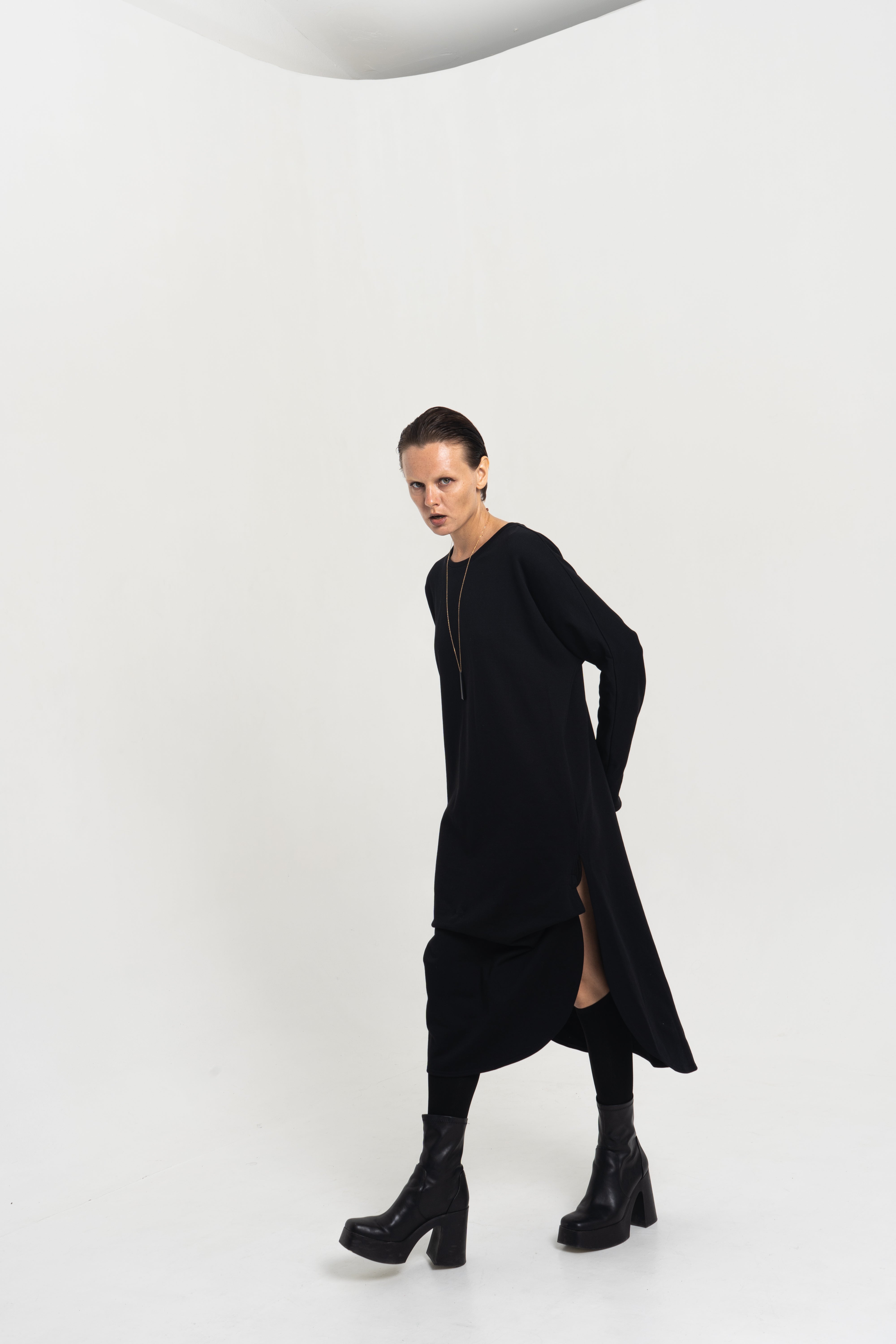 Female model wearing the Origami Tunic Shirt – side profile showing architectural drape
