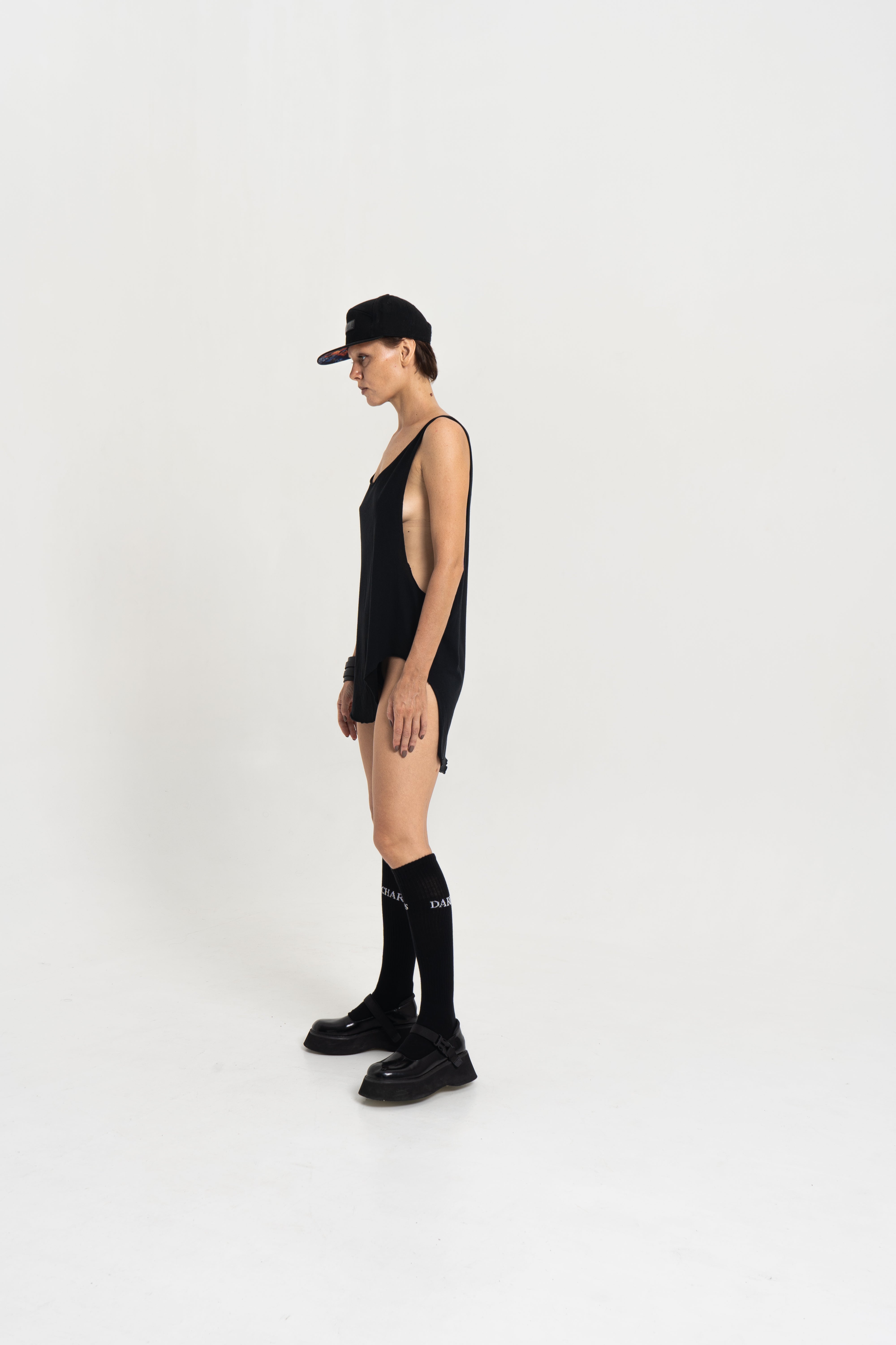 Model wearing the Charles Darius Deep Crew-Neck Tank in black, front view, standing against a white studio background.
